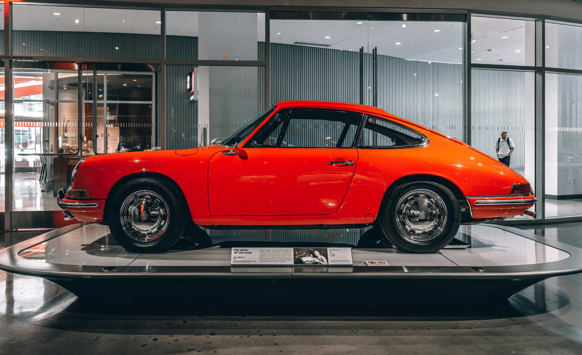 Classic red car displayed on platform indoors